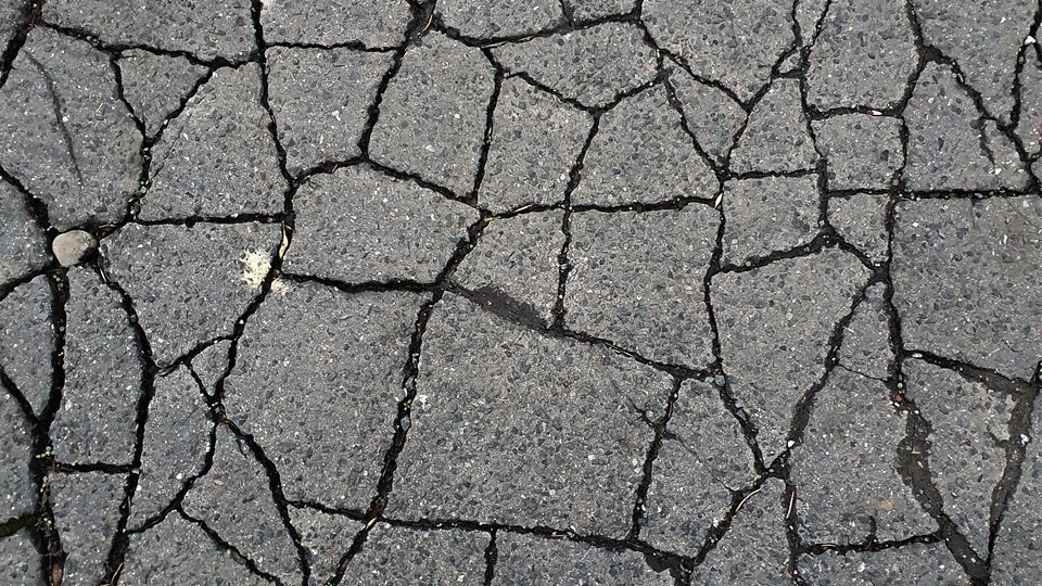 Interlocking alligator cracking across an asphalt surface, indicating base failure